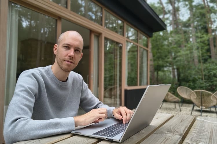jonas met laptop op terras